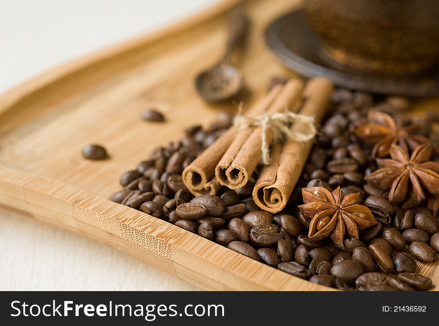 Coffee grains and spices on wooden background