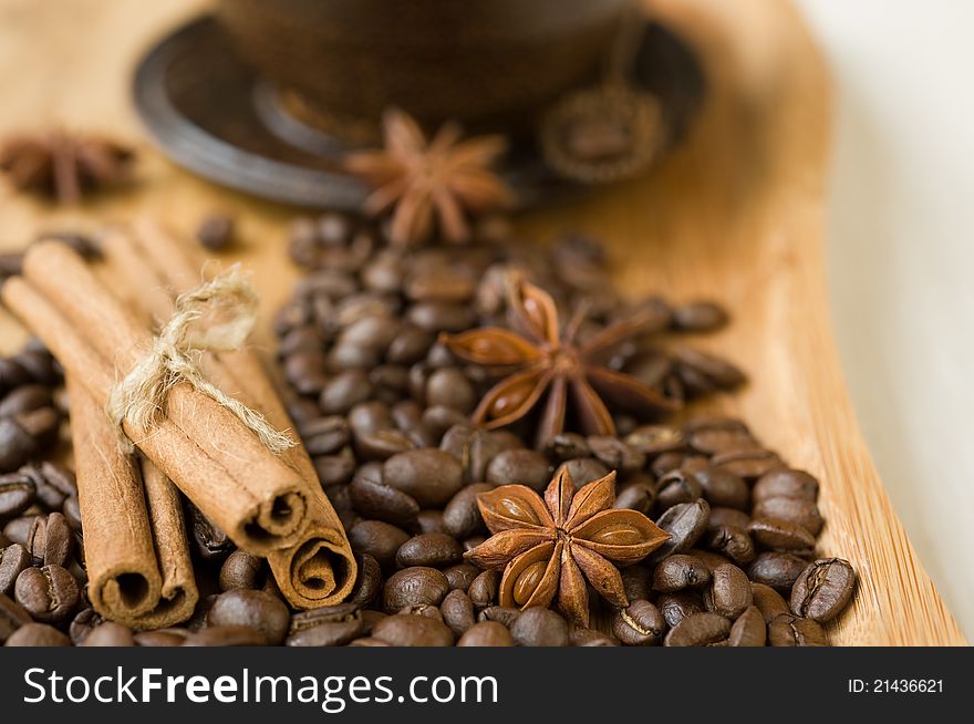 Coffee grains and spices on wooden background