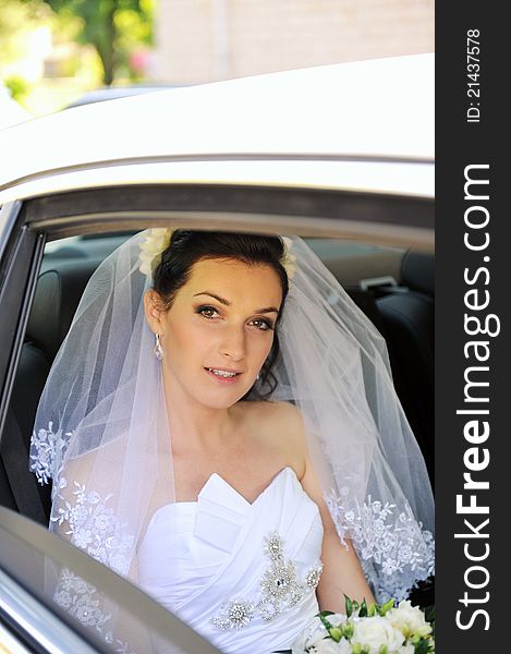 Bride with flowers in white car. Bride with flowers in white car
