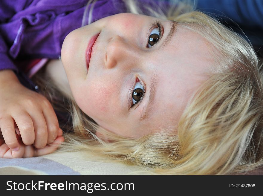 Beautiful little girl lying on bed at house