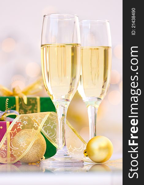 Glasses of champagne with gold ribbon and Christmas gifts. Glasses of champagne with gold ribbon and Christmas gifts