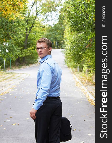 Businessman with computer in a park in autumn