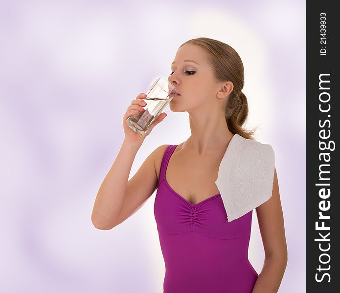 Beautiful athletic girl drinks water after a workout. Beautiful athletic girl drinks water after a workout