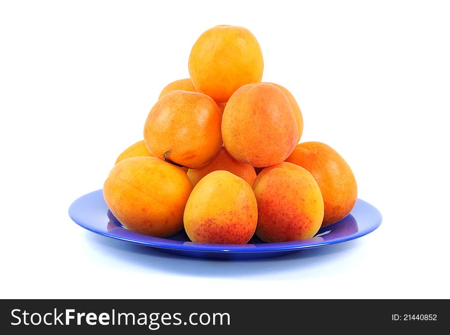 Fresh apricots on a blue plate, white background