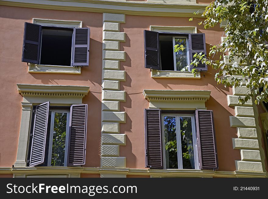 Four windows and vegetation in front of a modern building