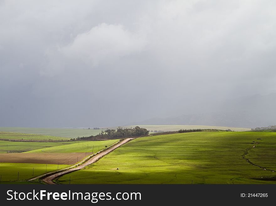 Green rural landscape with dirt road and storm clouds. Green rural landscape with dirt road and storm clouds