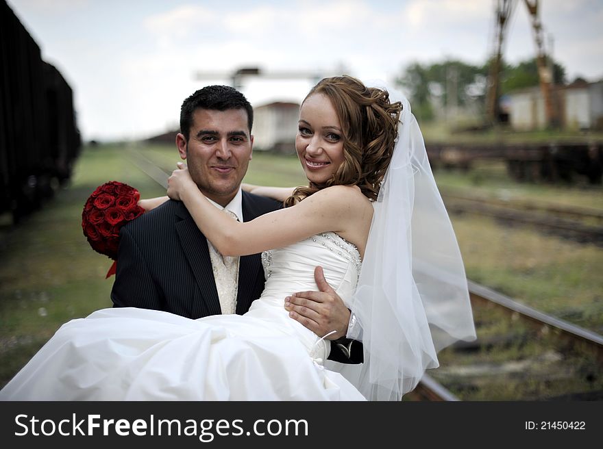 Portrait of happy and beautiful groom and bride embracing and looking at each-other with love. Portrait of happy and beautiful groom and bride embracing and looking at each-other with love