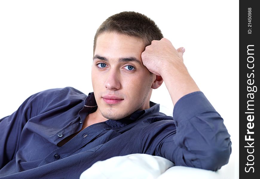 Portrait of young beautiful man lying on the sofa