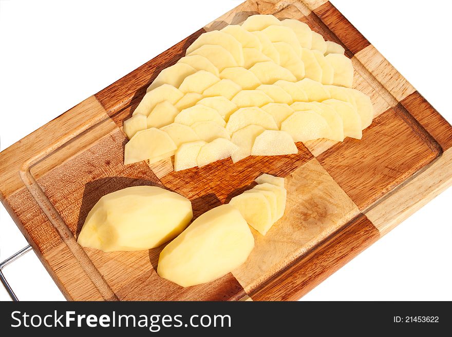 The potato sliced ​​on a cutting board at the white background. The potato sliced ​​on a cutting board at the white background