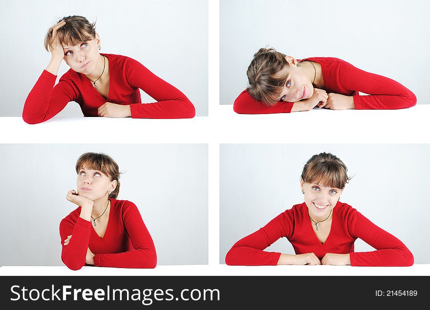 A pensive young woman in a red sweater at the desk, isolated on white