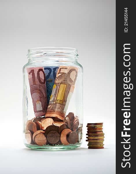 Euro coins and notes in a glass jar. Euro coins and notes in a glass jar