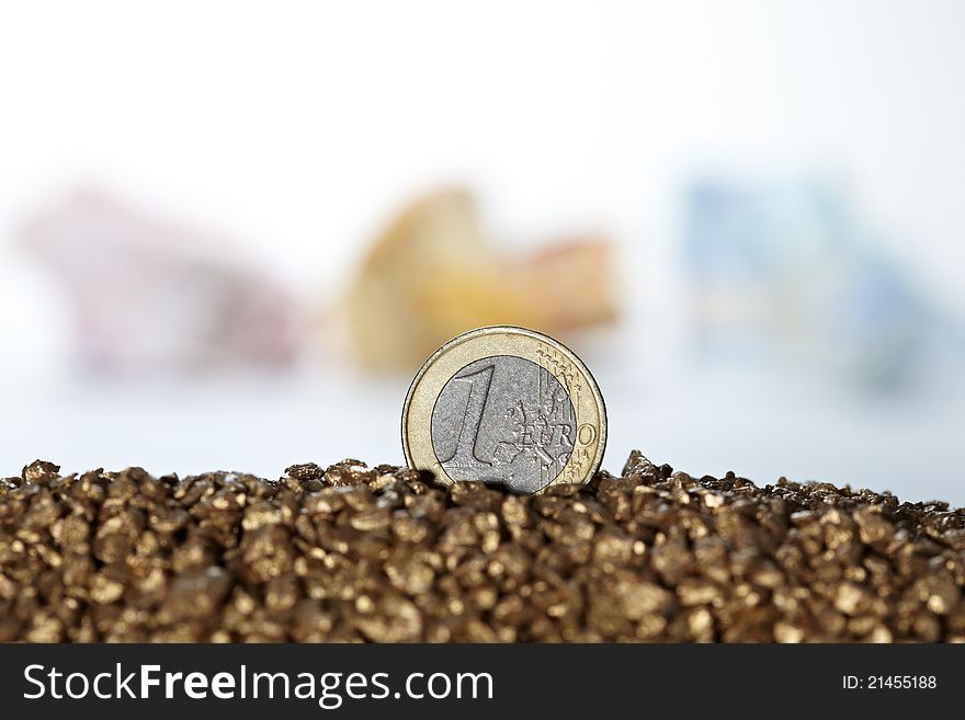 One euro coin standing alone in gold with background of other bank notes. One euro coin standing alone in gold with background of other bank notes