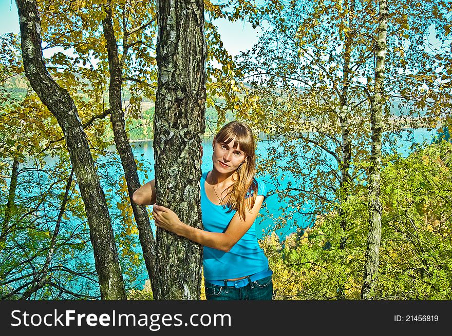 Girl in a suburban park in a forest and river. autumn. Girl in a suburban park in a forest and river. autumn