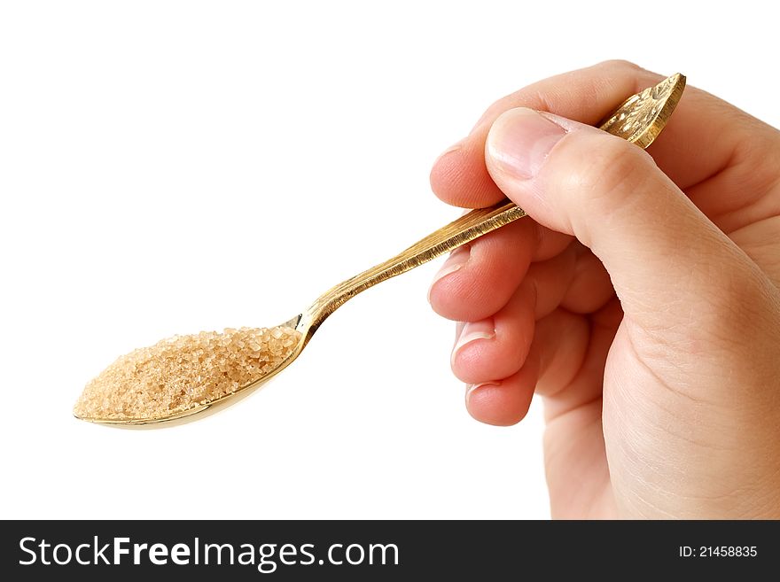 Hand holding spoon full of brown sugar