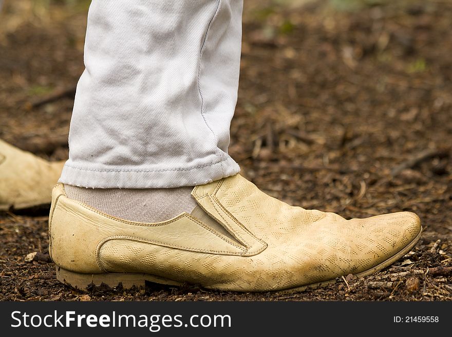 Human feet leather boots standing on the forest floor