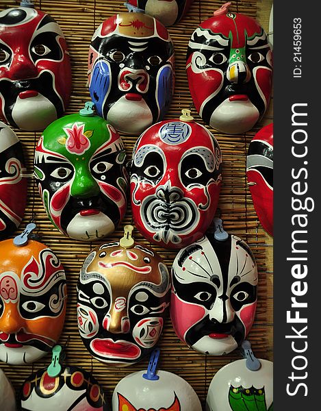 Colorful Chinese opera masks on a wall in a shop.