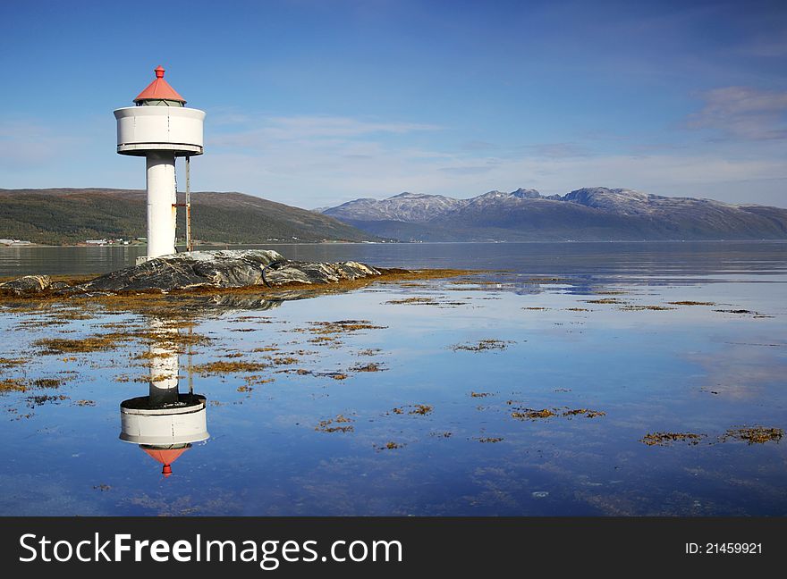 Little white lighthouse in the Norwegian fjords