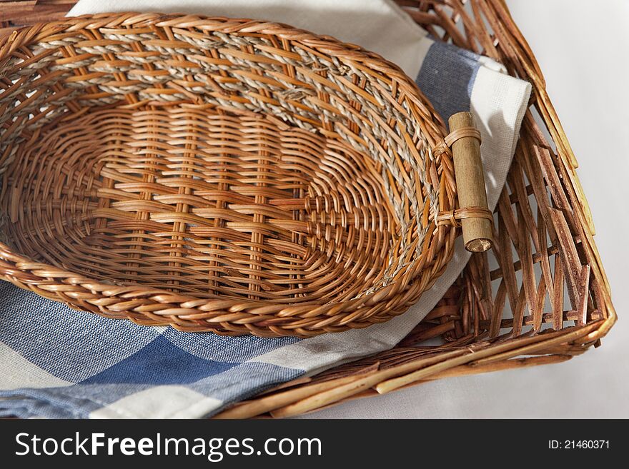 Brown wicker basket with a blue gingham cloth for table appointments