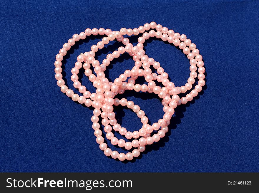 Beautiful pink pearl chains on blue background