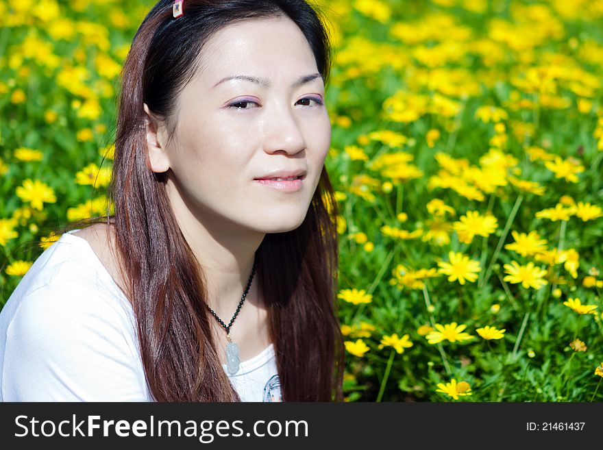 Portrait of the east asian woman, yellow flowers background