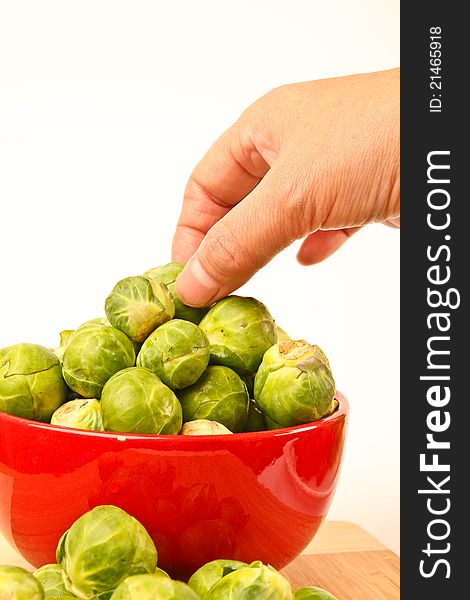 Fresh Brussels sprouts in a bowl. Close up on white background