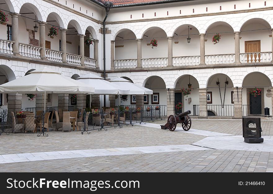 Courtyard in Niepolomice castle near Krakow, Poland, with an outdoor restaurant and cannon. Courtyard in Niepolomice castle near Krakow, Poland, with an outdoor restaurant and cannon