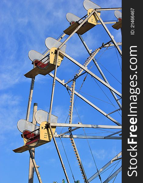 Seats of a ferris wheel against a blue sky