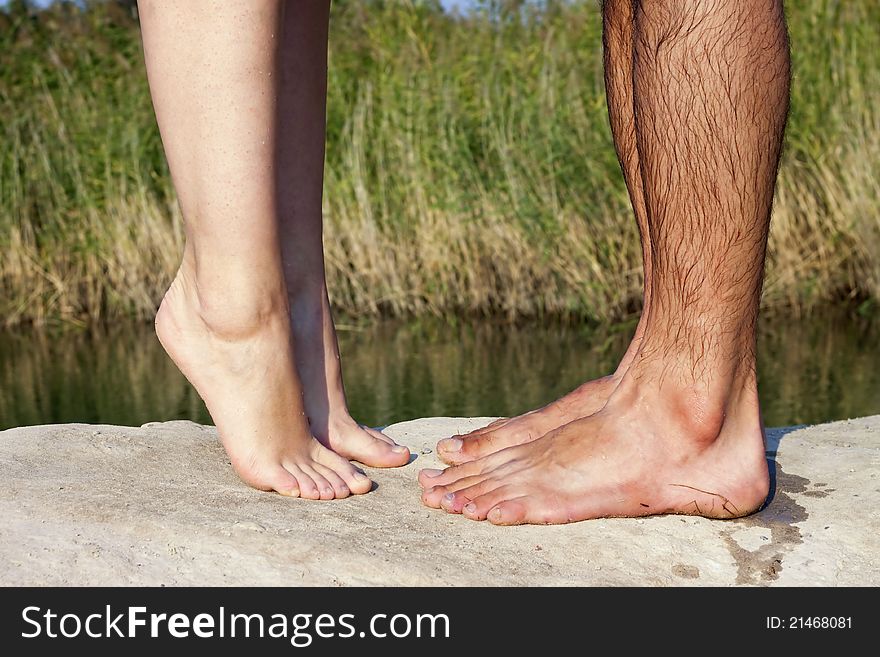 couple feet kissing near lake
