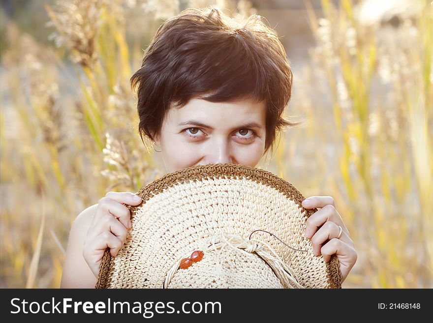 Portrait of beautiful brunette woman in summer reed