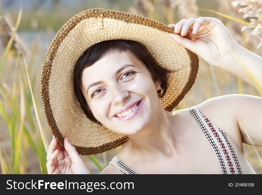 Portrait of beautiful brunette woman in summer reed