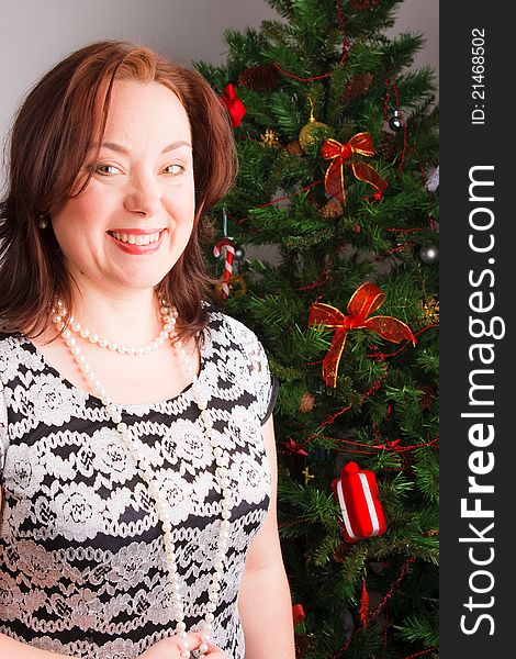 Mid adult woman near a new-year tree, closeup. Mid adult woman near a new-year tree, closeup