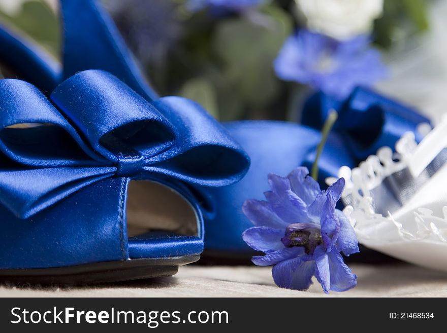 Blue wedding shoes and bouquet in the background