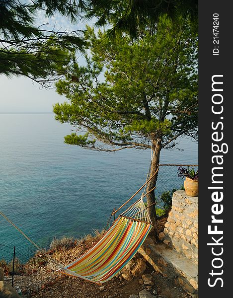 Rest and relaxation: hammok by the sea under a pine tree