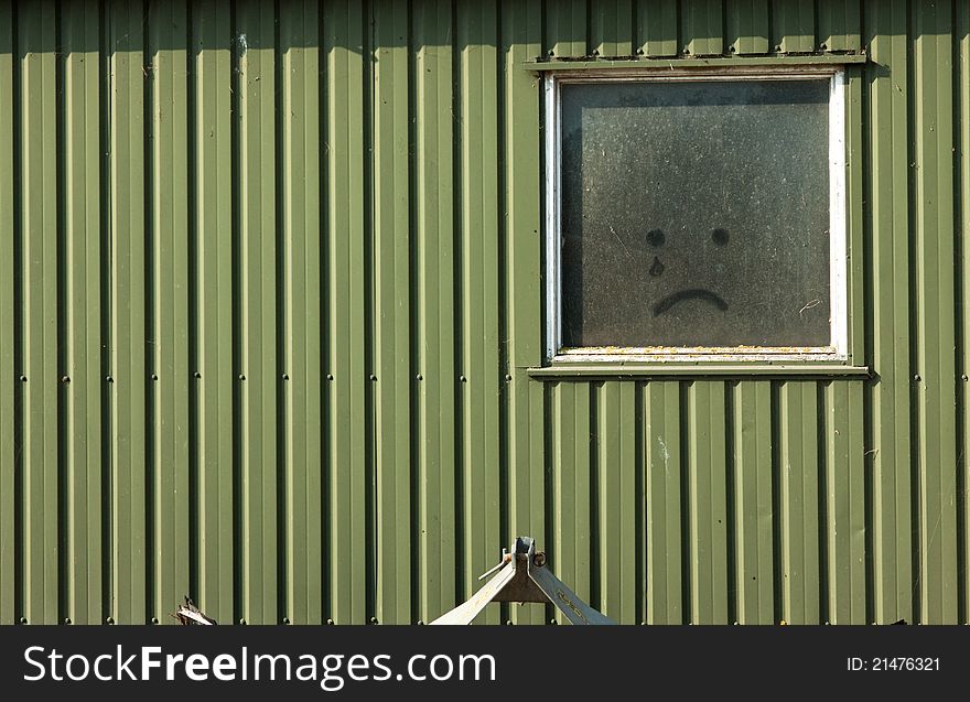 Wooden wall with drown crying smile on the window