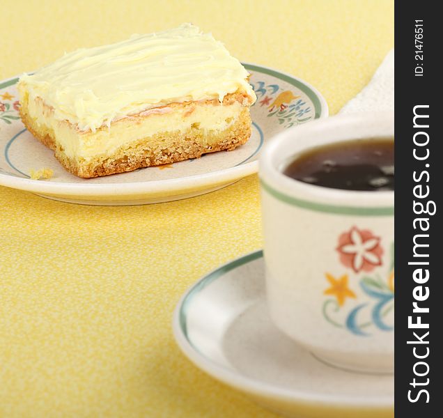 Selective focus on lemon square with cup of coffee. Selective focus on lemon square with cup of coffee