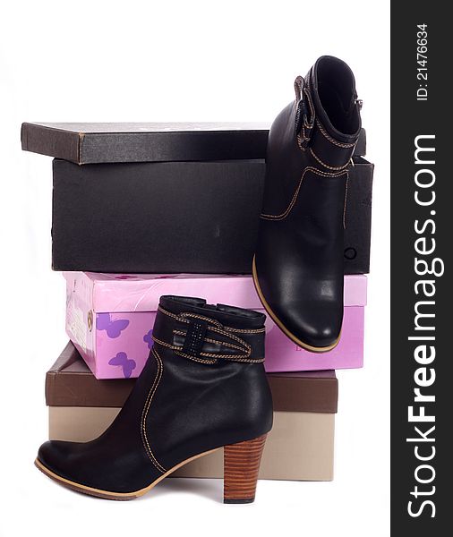Pair of black winter woman boots and many boxes over white
