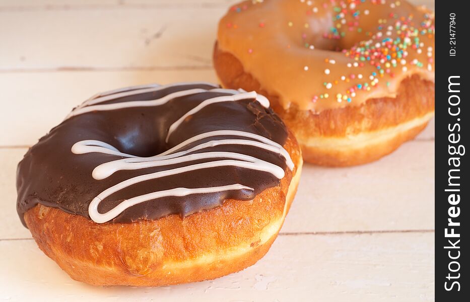 Two donuts covered in caramel and chocolate icing