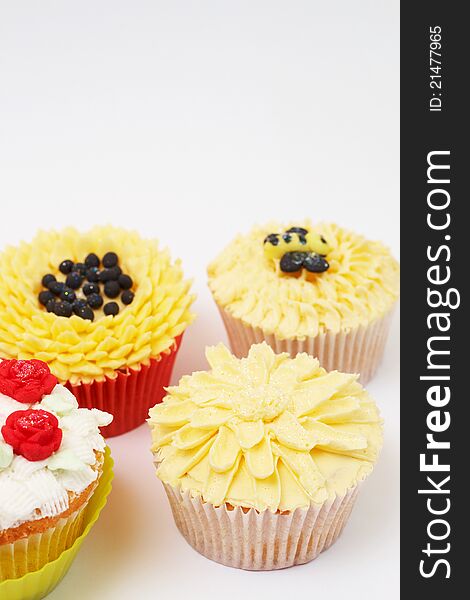 Variety of vanilla cupcakes with various buttercream decorations on light background. Variety of vanilla cupcakes with various buttercream decorations on light background