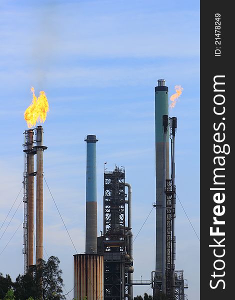 Flames coming out of free-standing chimneys of a refinery. Flames coming out of free-standing chimneys of a refinery