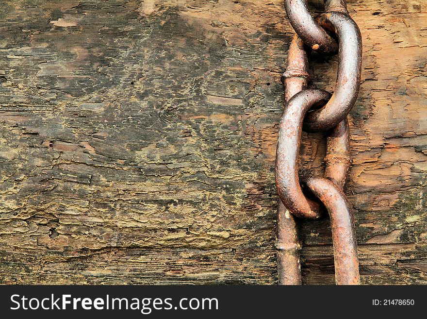 A thick anchor chain on a beached log. A thick anchor chain on a beached log.