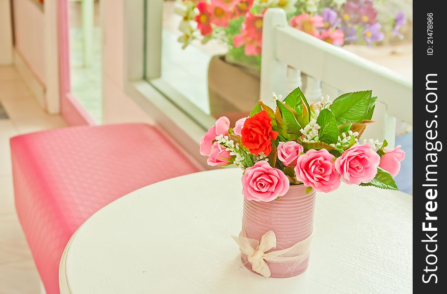 Pink artificial roses setting on white table