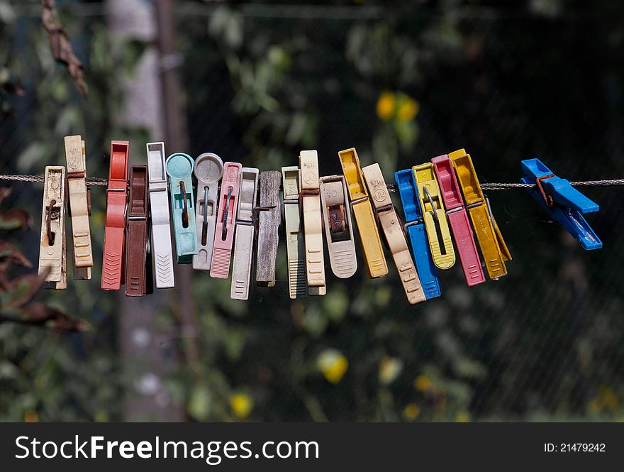 Old clothespins in a row on a rope