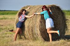 Girls Standing By Haystacks Stock Images