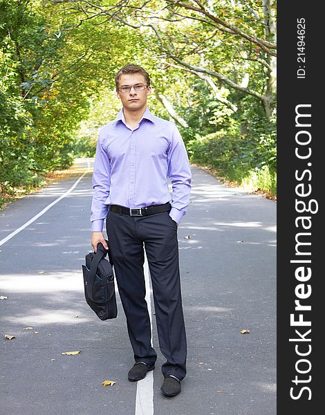 Businessman with computer in a park in autum