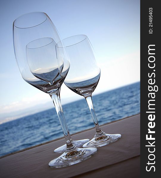 Wine glasses in front of sea and blue sky