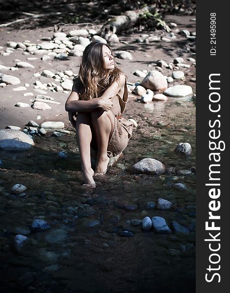 Young woman takes sunbath in mountains.