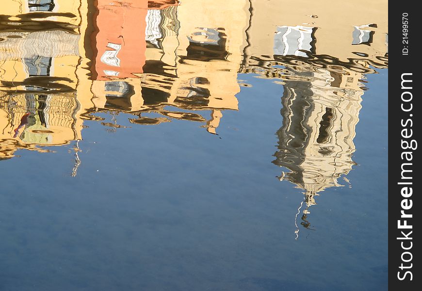 Reflection in the Onya River of some buildings along the river and of the San Fediu bell tower father behind. Reflection in the Onya River of some buildings along the river and of the San Fediu bell tower father behind.