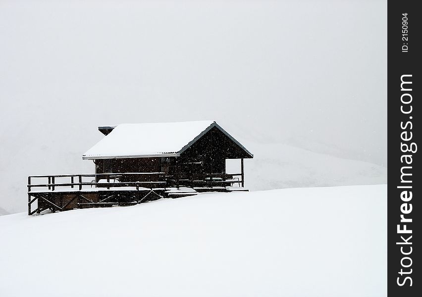 A mountain cottage in a winter day