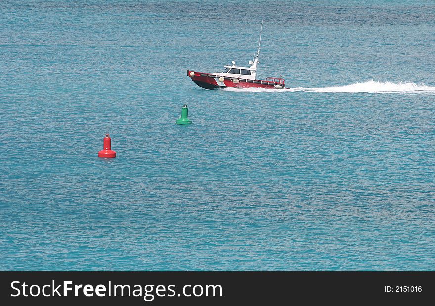 Red boat speeding through water past buoys. Red boat speeding through water past buoys