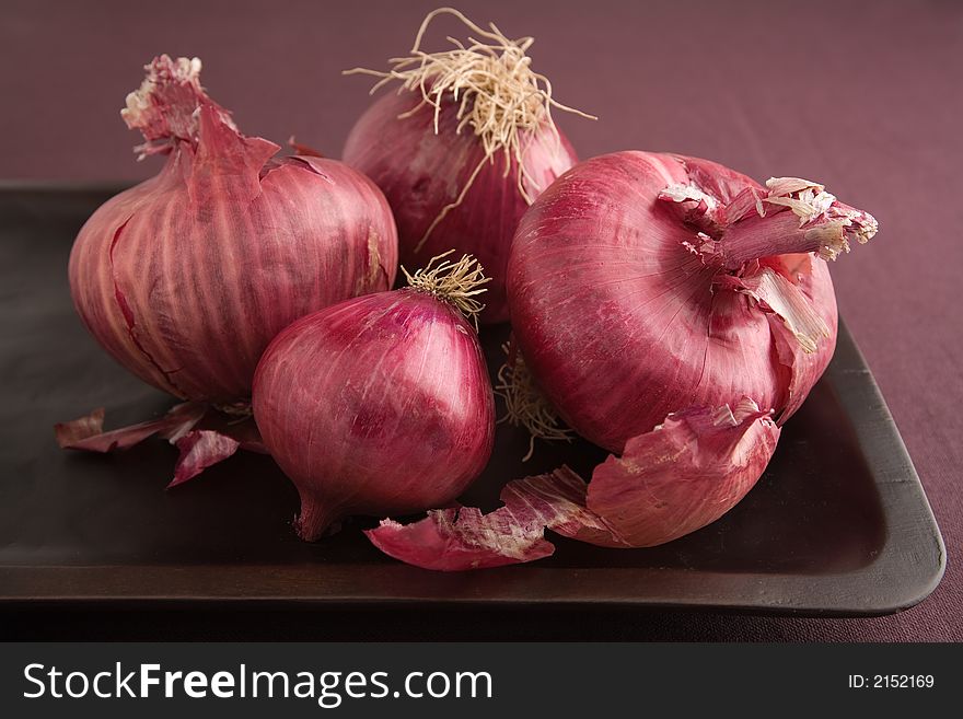 Arrangement of Red Onions on a wooden tray